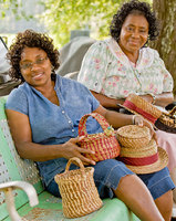 portrait of Mary Hicks and daughter Annette Jordan. Mary Hicks of Eutaw in Greene County is a practitioner of pine needle basketry. From the late Mabel
Means, she learned to make basic coiled baskets out of bundles of pine needles bound together with
thread or raffia. But she has expanded her work, adding decorative elements, such as corn shuck bows,
and coming up with her own designs. In addition to baskets she now makes hats, placemats, letter holders
and purses. 