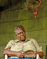 portrait of Odessa Rice of Eutaw, Alabama. Pine neetle basket maker. She
gathers the pine needles and boils them in a solution of water, salt and
vinegar. This gives them a gloss and helps to preserve them. It takes
her three to four hours to make a small basket by bundling pine needles
together, wrapping thread around them and forming coils that she sews
together, adding more pine straw as she goes.